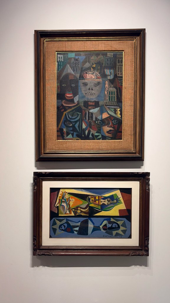 Duas pinturas de Di Cavalcanti penduradas uma sobre a outra, em molduras de madeira escura, com figuras fragmentadas em planos de cor